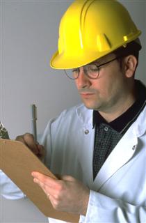 Man in hard hat reading clipboard