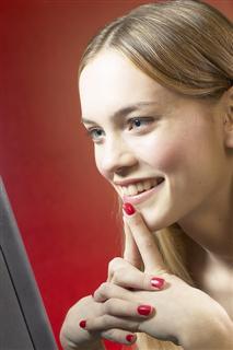 Smiling girl reading computer screen