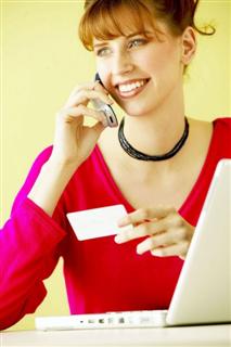 Woman at computer, holding business card