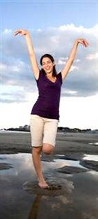 Woman on beach with arms raised